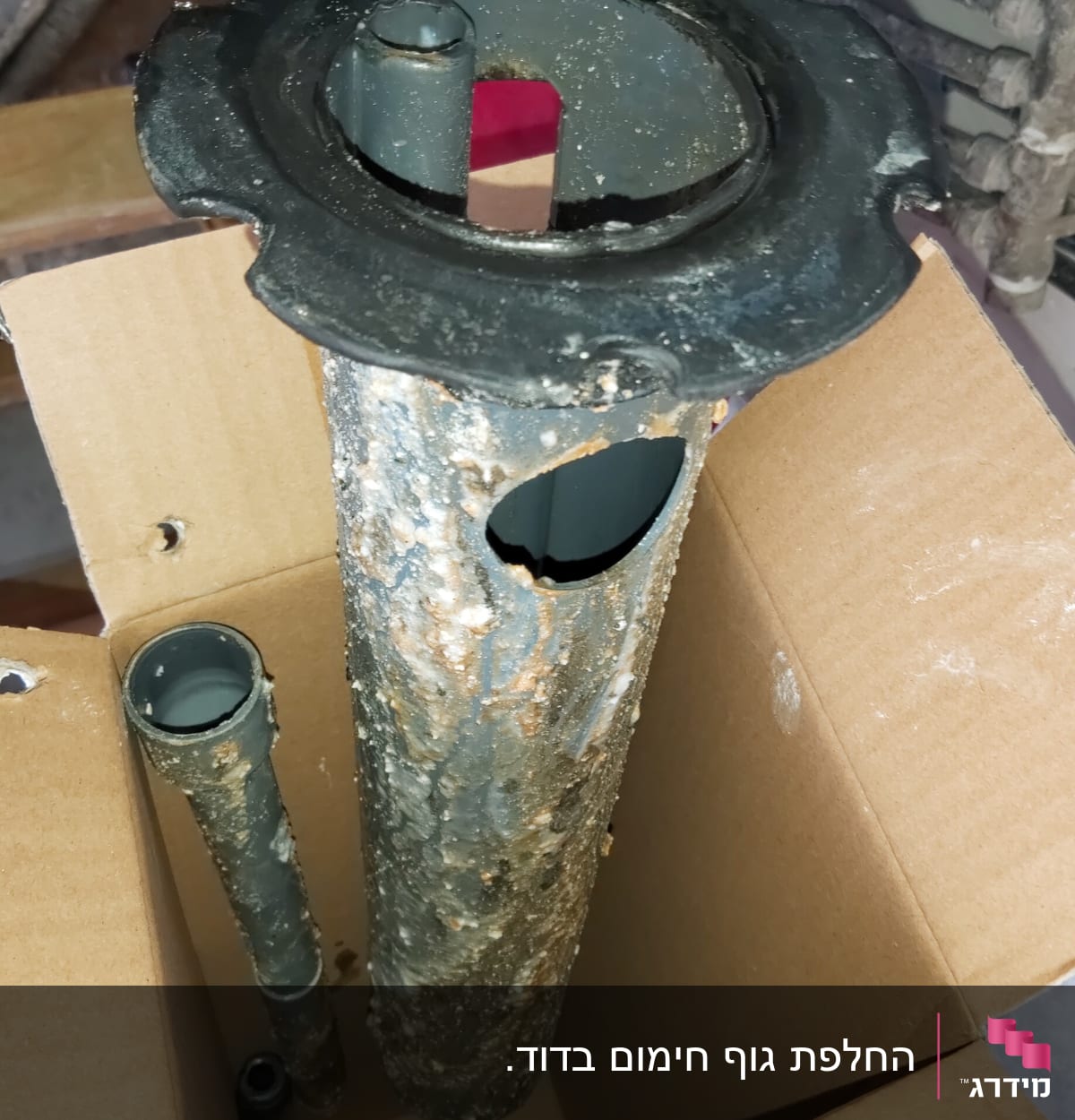 צינורות מתכת חלודים בתוך קופסת קרטון